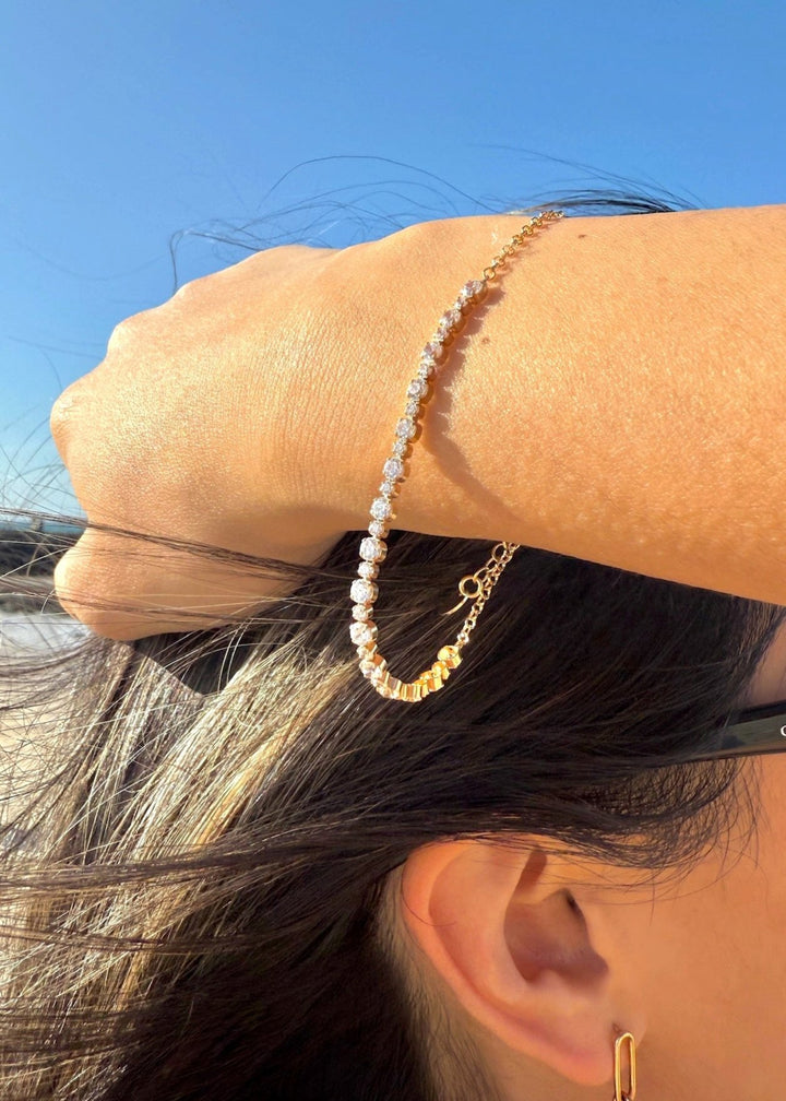 Gold alternating tennis bracelet in the wind